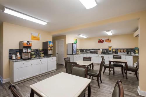 ein Restaurant mit Tischen und Stühlen und einer Küche in der Unterkunft Quality Inn & Suites Greensboro near Lake Oconee in Turnwold