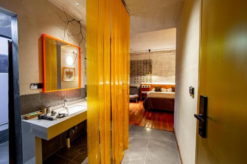 a bathroom with a sink and a room with a bed at Yabuli QuShe Four seasons Private Lakefornt B&B in Xinhua