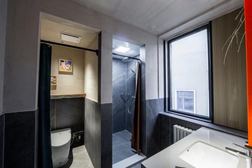 a bathroom with a toilet and a sink and a shower at Yabuli QuShe Four seasons Private Lakefornt B&B in Xinhua