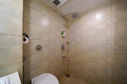 a bathroom with a toilet and a shower at Open Hotel by Olive - The Infantry Hotel in Bangalore