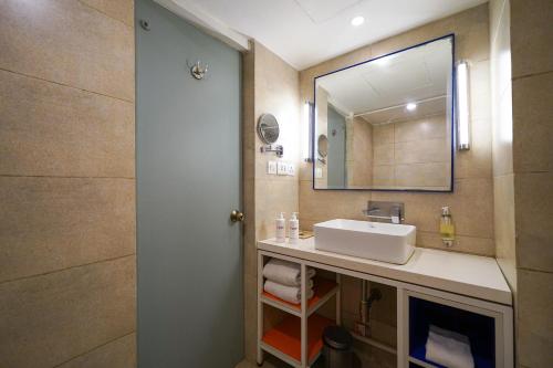 a bathroom with a sink and a mirror at Open Hotel by Olive - The Infantry Hotel in Bangalore