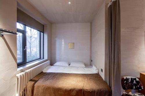 a bed in a room with a window at Yabuli QuShe Four seasons Private Lakefornt B&B in Xinhua
