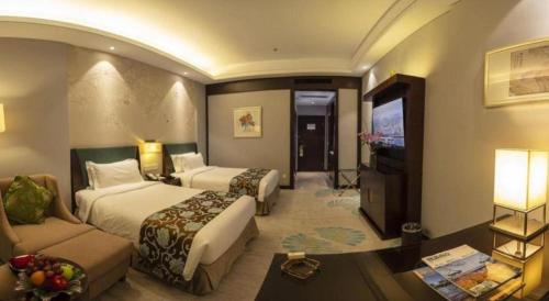 a hotel room with two beds and a television at Jin Jiang Nanjing Hotel in Nanjing