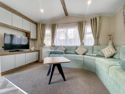 a living room with a blue couch and a table at Brookwood in Weston-super-Mare