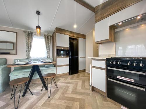 une cuisine avec une table et une cuisinière four supérieur dans l'établissement Brookwood, à Weston-super-Mare