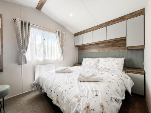 a bedroom with a bed with two towels on it at Brookwood in Weston-super-Mare