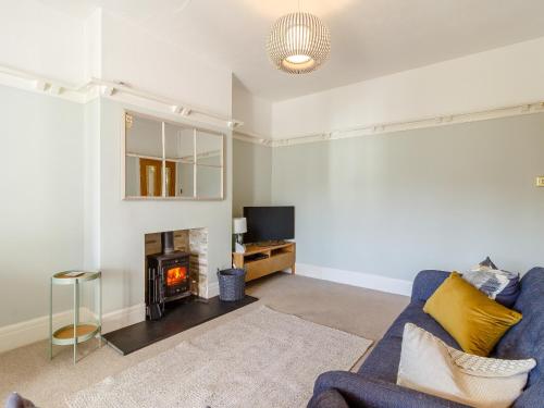 a living room with a blue couch and a fireplace at Court House in Porthcawl