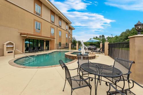 a patio with a table and chairs next to a pool at Sleep Inn Lufkin in Lufkin