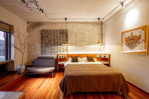 a bedroom with a bed and a chair at Yabuli QuShe Four seasons Private Lakefornt B&B in Xinhua