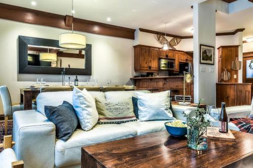 una sala de estar con un sofá y una mesa en Le Plateau Ski Inout W 3bdrs W Pool Access, en Mont-Tremblant
