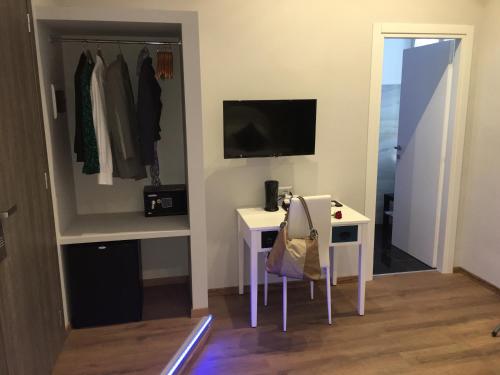 a small room with a desk and a tv and a closet at Roma Veneto Relais in Rome