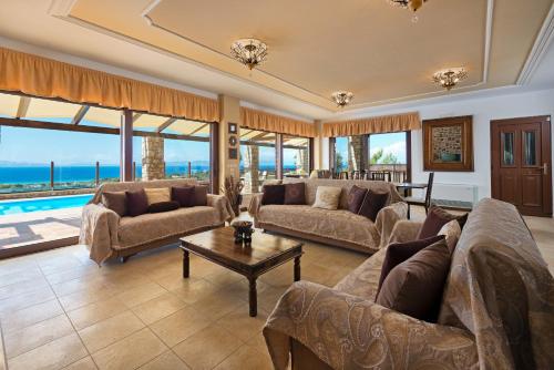 a living room with couches and a table at Butterfly Villa in Theologos