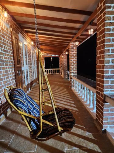 a swing on the porch of a building at The Windsor Villa in Mahirāvani