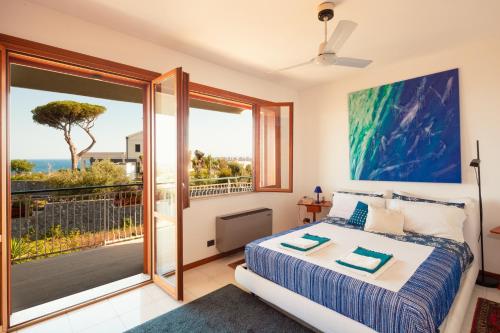 a bedroom with a bed and a view of the ocean at Villa Cannizzaro in Catania
