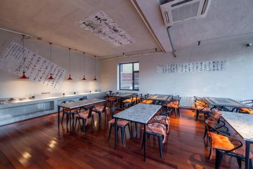 a restaurant with tables and chairs in a room at Yabuli QuShe Four seasons Private Lakefornt B&B in Xinhua