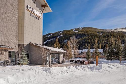 a hotel in the snow with a mountain in the background at Cambria Hotel Copper Mountain in Frisco
