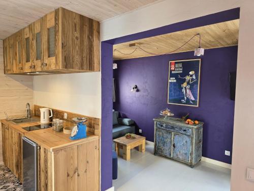 a kitchen with purple walls and wooden cabinets at SOBIESZEPTY Odetchnij ciszą in Gdańsk