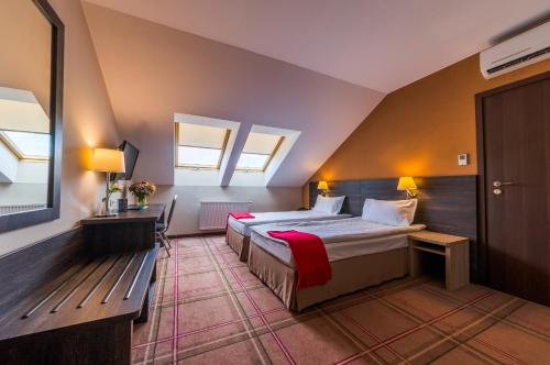 a bedroom with a bed and a bench in a room at Mikołajki Resort Hotel & Spa Jora Wielka in Mikołajki