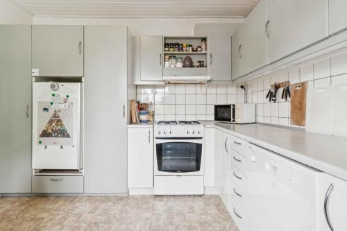 a kitchen with white appliances and white cabinets at Family Holiday Near Beach, Town And Nature in Svaneke