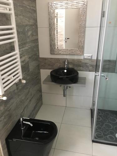a bathroom with a black toilet and a mirror at Roma Veneto Relais in Rome