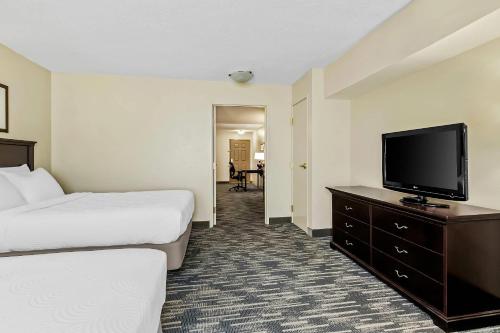 a hotel room with two beds and a flat screen tv at Country Inn & Suites by Radisson, Princeton, WV in Princeton