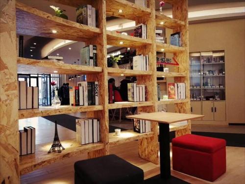 a library with a wooden wall filled with books at ibis Shenyang north station in Shenyang