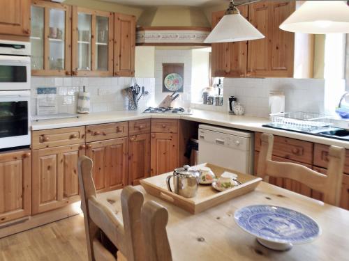 a kitchen with wooden cabinets and a wooden table at May Cottage in Bakewell