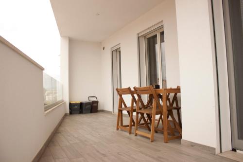 a room with a table and chairs on a balcony at Gioja suite in Quartu SantʼElena