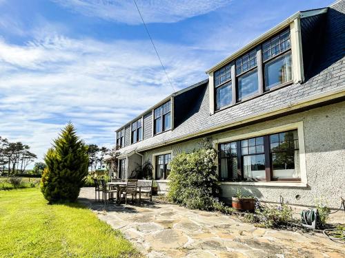 a house with a table and chairs in front of it at Fourpenny Cottage - Uk34744 in Embo