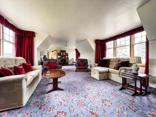 a living room with two couches and a table at Fourpenny Cottage - Uk34744 in Embo