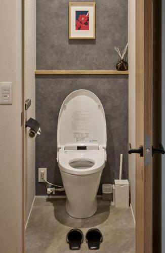a toilet with the lid up in a bathroom at 綯 -NAU- in Yakushima