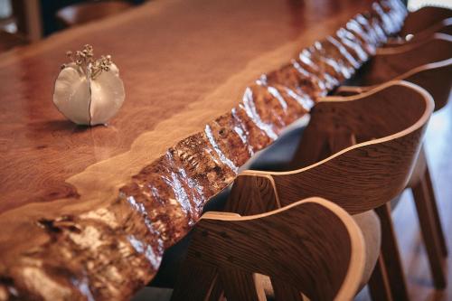 a wooden table with a bunch of chairs around it at 綯 -NAU- in Yakushima