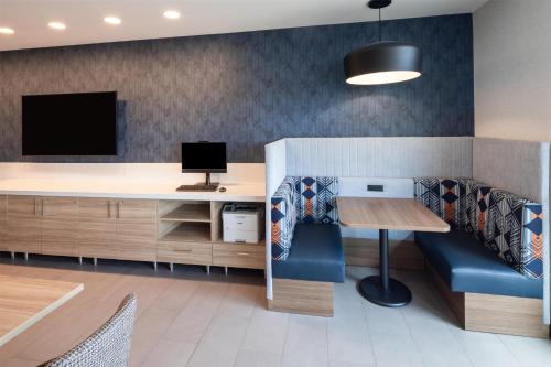 an office with a desk with a computer and a blue couch at Home2 Suites By Hilton Kalispell, Mt in Kalispell