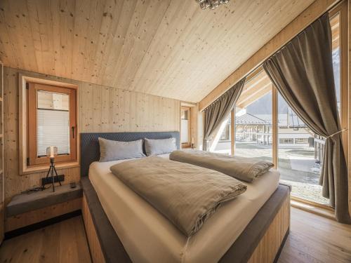 a bedroom with a large bed and a large window at Chalet in Bichlbach near Ski Slopes in Bichlbach