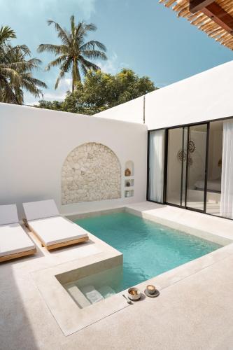 a swimming pool in the middle of a house at Kasih 2 - Villa with private pool in Gili T in Mantaak