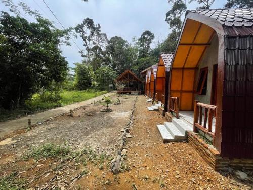 a row of small buildings on a dirt road at Ecotourism Bukit Lawang Bungalow in Bukit Lawang
