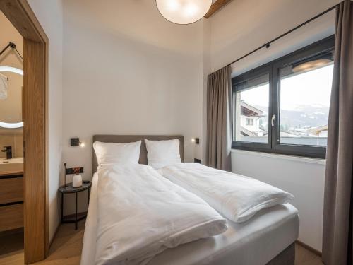 a white bed in a room with a window at Apartment in Kirchberg near Ski Lift in Kirchberg in Tirol