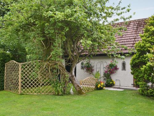 a tree in front of a house with a gate at The Studio in Warkworth