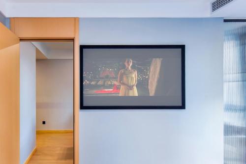 a television hanging on a wall in a room at Aimoke hotel in Chongqing