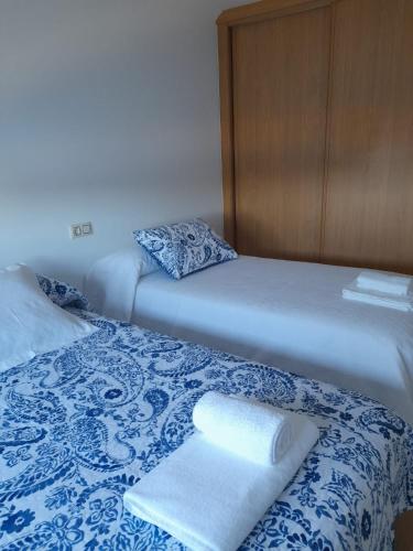 a bedroom with two beds with towels on them at Mareira in Camariñas