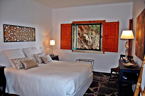 a bedroom with a white bed and a window at Mar de Serra in Rio Maior