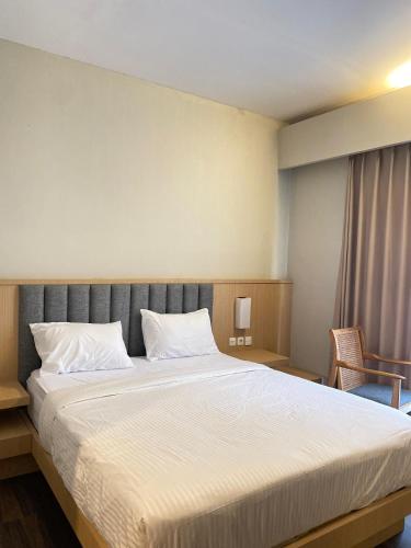 a bedroom with a large bed with white sheets at Regato Suites in Jakarta