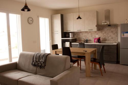 a living room with a couch and a table and a kitchen at Gioja suite in Quartu SantʼElena