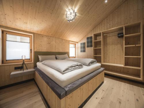a bedroom with a large bed in a wooden room at Chalet in Bichlbach near Ski Slopes in Bichlbach