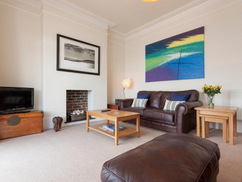 a living room with a couch and a fireplace at Oystercatcher in Kingswear