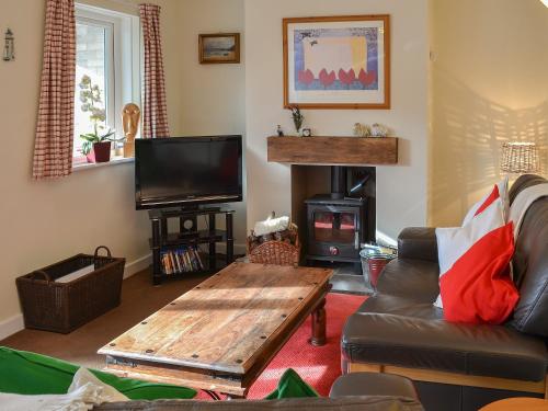 a living room with a couch and a coffee table at Fairways in Beadnell
