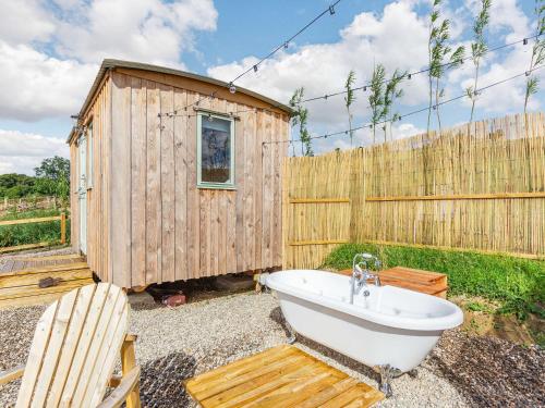 a bathroom with a tub and a wooden fence at Woodside Hut 1 - Uk36105 in Auchterneed