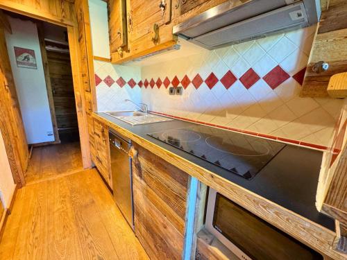 une cuisine avec un évier et une cuisinière dans l'établissement Résidence Necou - Studio avec lit clos savoyard au bord des pistes MAE-5374, aux Menuires