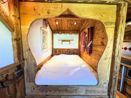 - un lit dans une petite chambre dans une cabine dans l'établissement Résidence Necou - Studio avec lit clos savoyard au bord des pistes MAE-5374, aux Menuires