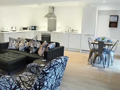 a living room with a couch and a table with chairs at Alnwick Malthouse in Alnwick
